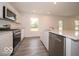 Well-lit kitchen boasts modern stainless steel appliances and a center island with a sink at 7509 Big Bend Blvd, Camby, IN 46113