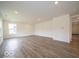 Spacious living room featuring modern wood-style floors and a large window for ample natural light at 7509 Big Bend Blvd, Camby, IN 46113