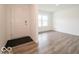 Bright living room with hardwood flooring, a white door, and natural light from the window at 7509 Big Bend Blvd, Camby, IN 46113