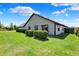 Well-maintained backyard with lush green grass, manicured shrubs, and a view of the home at 7702 Justin Ln, Indianapolis, IN 46219