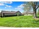 Charming home with a well-manicured lawn, mature trees, and vibrant greenery at 7702 Justin Ln, Indianapolis, IN 46219