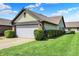 Spacious front yard with a two-car garage and lush green landscaping, creating a welcoming outdoor space at 7702 Justin Ln, Indianapolis, IN 46219