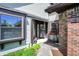Inviting entrance showcasing a brick accent wall, cozy bench, and well-manicured greenery, offering curb appeal at 7702 Justin Ln, Indianapolis, IN 46219