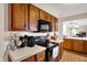 Well-lit kitchen with updated appliances, classic wood cabinetry, and functional layout for meal preparation, a cozy space at 7702 Justin Ln, Indianapolis, IN 46219