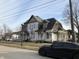 Two story home with covered porch and peeling paint needing repairs at 802 S Anderson St, Elwood, IN 46036
