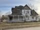 Two story home with covered porch and peeling paint in need of renovation at 802 S Anderson St, Elwood, IN 46036