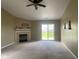 Spacious carpeted living room with a fireplace, ceiling fan, and sliding glass doors to the backyard at 8054 Painted Pony Dr, Indianapolis, IN 46217
