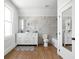 Bright bathroom with tiled walls, window, and natural wood floor at 809 N Temple Ave, Indianapolis, IN 46201