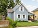 Quaint two-story home with light blue siding, white trim, and a lush green lawn with mature trees at 809 N Temple Ave, Indianapolis, IN 46201