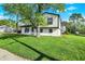Charming two-story home with well-maintained lawn, bright white siding, black trim, and mature shade tree at 8103 Laughlin Dr, Indianapolis, IN 46219
