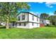 Charming two-story home with well-maintained lawn, bright white siding, black trim, and mature shade tree at 8103 Laughlin Dr, Indianapolis, IN 46219