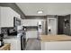 Bright kitchen features an island, stainless steel appliances and views of a stairway at 8103 Laughlin Dr, Indianapolis, IN 46219
