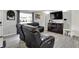 Cozy living room with a modern entertainment center, gray walls, and plush, black leather reclining furniture at 8103 Laughlin Dr, Indianapolis, IN 46219