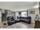 Inviting living room featuring a large, comfortable, black leather sectional and stylish gray walls with wood-look flooring at 8103 Laughlin Dr, Indianapolis, IN 46219