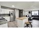 Open-concept kitchen with stainless steel appliances, island and barstools that flows into a living room at 8103 Laughlin Dr, Indianapolis, IN 46219