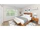 Comfortable bedroom with a large window, light colored walls, and a neutral-toned rug at 8108 Amarillo Dr, Indianapolis, IN 46237