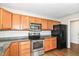 View of kitchen featuring stainless steel appliances, granite countertop, and wooden cabinets at 8108 Amarillo Dr, Indianapolis, IN 46237