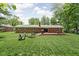 Great backyard with mature trees, a fire pit, and a deck for outdoor living at 818 Merry Ln, Greenwood, IN 46142