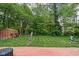 Lush backyard featuring mature trees, a shed, and a deck for outdoor enjoyment at 818 Merry Ln, Greenwood, IN 46142
