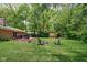 Expansive backyard featuring a fire pit, mature trees, and a brick patio for outdoor entertaining at 818 Merry Ln, Greenwood, IN 46142