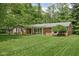 Well-manicured front lawn and landscaped yard of the home with brick exterior at 818 Merry Ln, Greenwood, IN 46142