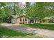 Charming brick home featuring an attached garage, gravel driveway, and well-maintained landscaping at 818 Merry Ln, Greenwood, IN 46142