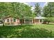 Charming brick ranch-style home featuring a well-manicured lawn and mature trees at 818 Merry Ln, Greenwood, IN 46142