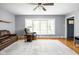 Light-filled living room with wood floors, a large window, and a comfortable leather sofa at 818 Merry Ln, Greenwood, IN 46142