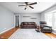 Spacious living room boasting beautiful hardwood floors, leather furniture, and a ceiling fan at 818 Merry Ln, Greenwood, IN 46142