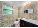 Vibrant bathroom featuring orange and white floral wallpaper, a mirror, and a vanity with a sink at 8227 Hoover Ln, Indianapolis, IN 46260