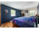 Comfortable bedroom with hardwood floors, a galaxy themed comforter, and a dark blue accent wall at 8227 Hoover Ln, Indianapolis, IN 46260
