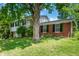 A view of the exterior of the two-story home on a green, grassy lawn with a large tree providing shade at 8227 Hoover Ln, Indianapolis, IN 46260