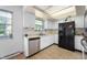 Bright kitchen with white cabinets, stainless steel dishwasher and black refrigerator, and plenty of natural light at 8227 Hoover Ln, Indianapolis, IN 46260