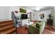 Cozy living room view showcases decor, including the green couch and open staircase at 8227 Hoover Ln, Indianapolis, IN 46260