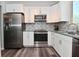 Kitchen featuring white cabinets, stainless appliances, and mosaic backsplash at 8627 Lansdowne Dr, Fishers, IN 46038