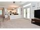 Bright living room with French doors, a cozy fireplace, and a seamless flow to the kitchen at 8627 Lansdowne Dr, Fishers, IN 46038