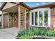 Inviting front porch with lattice details, brick accents and lush landscaping around the bay window at 8834 W 1050 S, Fortville, IN 46040