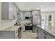 Bright kitchen featuring stainless steel appliances, gray cabinets, and a view of the backyard at 8834 W 1050 S, Fortville, IN 46040
