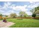 A wide green backyard featuring a wood fence, small patio, and access to the pond at 905 N Main St, Fortville, IN 46040