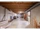 Unfinished basement with exposed wood ceiling, concrete floor, and ample space at 905 N Main St, Fortville, IN 46040