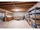 Unfinished basement with exposed wood ceiling, concrete floor, and storage areas at 905 N Main St, Fortville, IN 46040