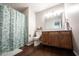 Bathroom with a wood vanity, a patterned shower curtain, modern lighting, and wood flooring at 905 N Main St, Fortville, IN 46040