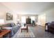 Living room with comfortable gray sofas, accent chairs, and soft carpet at 905 N Main St, Fortville, IN 46040
