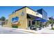 Charming corner restaurant with outdoor seating and a vibrant mural on the yellow brick wall at 905 N Main St, Fortville, IN 46040