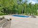 A spacious backyard with a large pool, outdoor seating, a dining area, and landscaped features, perfect for entertaining at 9155 Kerwood Dr, Indianapolis, IN 46240