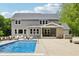 Large backyard features a swimming pool, outdoor seating, an outdoor dining area, a spa, and lush landscaping at 9155 Kerwood Dr, Indianapolis, IN 46240