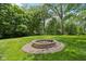 This backyard features a fire pit surrounded by lush greenery, creating a cozy spot for outdoor gatherings at 9155 Kerwood Dr, Indianapolis, IN 46240