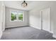 Spacious bedroom with neutral tones, large window with backyard view, and modern ceiling fan at 9155 Kerwood Dr, Indianapolis, IN 46240