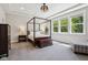 Spacious primary bedroom with a canopy bed, sitting area, and bright windows offering a view at 9155 Kerwood Dr, Indianapolis, IN 46240