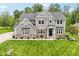Beautiful two-story home with a stone and siding exterior, lush green lawn, and manicured landscaping at 9155 Kerwood Dr, Indianapolis, IN 46240